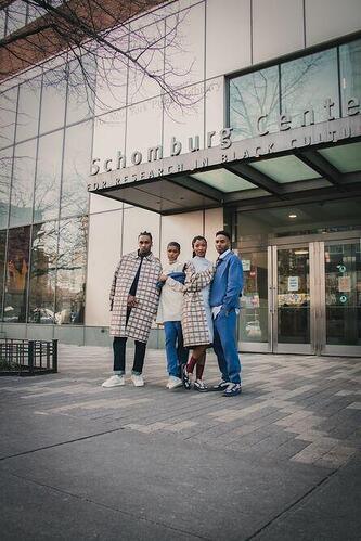 Four people stand outside the Schomburg Center.